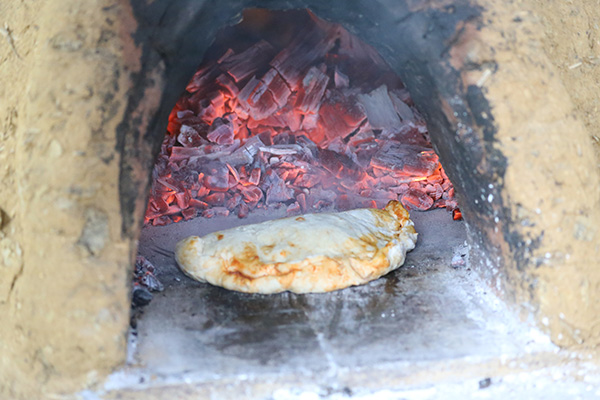 Cooking pizza in the wood-fired oven 